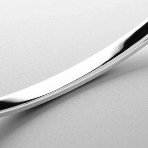 Macro shot of mirror-polished stainless steel bangle showing smooth curved metal edges