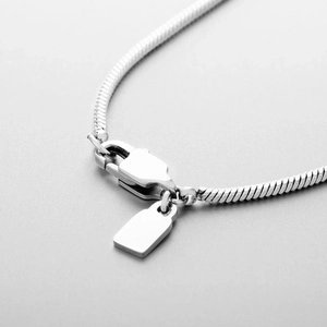 Detailed close-up of stainless steel snake chain with lobster clasp and metal tag