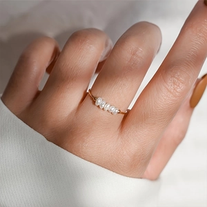 Minimalist gold stainless steel ring featuring five natural freshwater pearls in a row