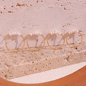 Close-up of four gold stainless steel rings with delicate natural freshwater pearls