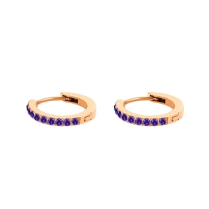 Dettaglio di orecchini a cerchio in oro rosa con zirconi viola incastonati a canale