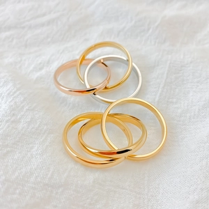 Elegant multi-color stainless steel interlocking rings set on soft white fabric background