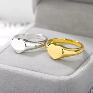 Polished heart signet rings in gold and silver finish displayed in a jewelry box