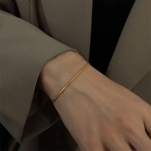 Minimalist gold-plated stainless steel round snake chain bracelet worn on the wrist