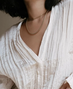 Vue détaillée d'un collier à double rangée de chaînes dorées porté par un mannequin