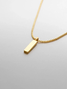 Close-up of golden stainless steel box chain with a minimalist rectangular bar pendant