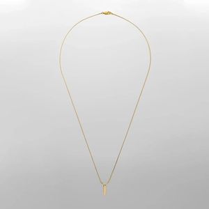 Gros plan sur la chaîne serpent dorée avec pendentif cylindrique poli et fermoir mousqueton