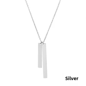 Detailed close-up of two silver vertical bar pendants on a sleek stainless steel chain