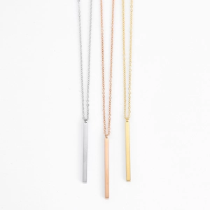 Detailed view of minimalist vertical bar pendants in silver, gold, and rose gold finishes