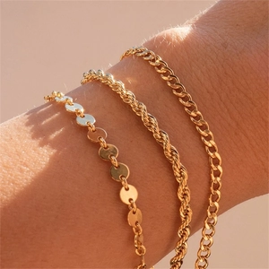 Three-piece gold stainless steel bracelet set featuring disc, rope, and curb chain styles
