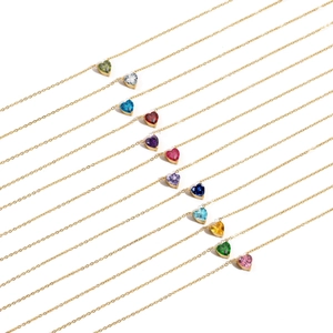 Vue macro de douze colliers à pendentifs en cristal en forme de cœur et acier doré