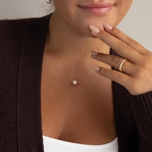 Elegant gold stainless steel necklace featuring a white pearl and red zircon gemstone pendant