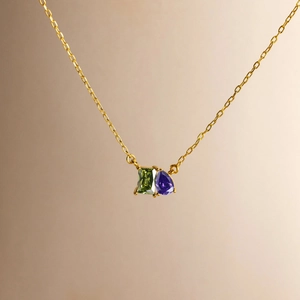 14k Goldkette mit smaragdgrünem Stein und lilafarbenem Tropfenanhänger im Detail