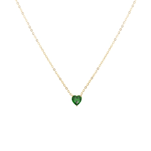 Détail d'un collier en acier doré avec pendentif en cristal vert en forme de cœur