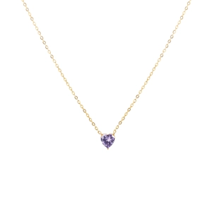 Détail d'un pendentif en pierre violette en forme de cœur sur une fine chaîne dorée