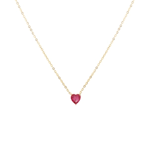 Gros plan du collier doré avec un pendentif en pierre rouge en forme de cœur et chaîne