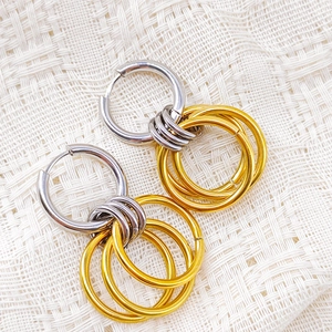 Polished stainless steel two-tone hoop earrings with dangling gold and silver rings