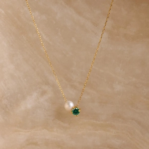 Detailed close-up of 14K gold plated necklace with white pearl and green gemstone pendant