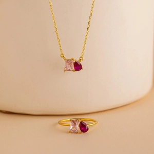 Detailed shot of heart pendant necklace and ring with pink and red zircon stones