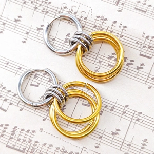 Detail of interlocking silver and 18K gold two-tone stainless steel hoop earrings