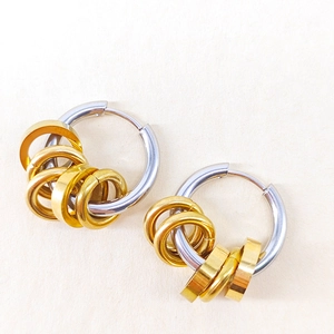 Detail of two-tone stainless steel hoop earring with silver base and gold ring accents