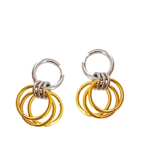Detailed view of silver hoop earrings featuring three hanging golden rings on white background