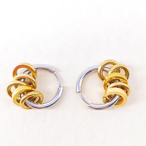 Close-up of two-tone stainless steel hoop earrings with small gold ring accents