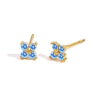 Makroaufnahme goldener Kleeblatt-Ohrstecker mit hellblauen Geburtsstein-Blütenblättern