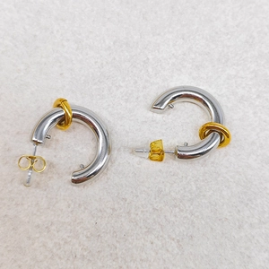 Macro shot of 18k gold plated C-shaped chunky hoop earrings with decorative gold rings