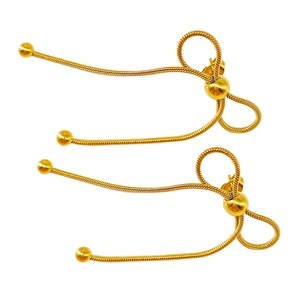 Detailed close-up of gold bow earrings featuring a snake chain weave and metallic beads
