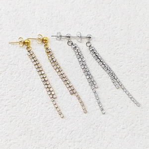 Detail of elegant gold and silver double-row tassel earrings with sparkling cubic zirconia