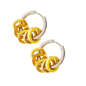 Detail of silver stainless steel hoops with hanging gold rings in mixed metal style