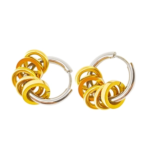 Macro shot of silver hoop earrings with gold contrast small rings and polished finish