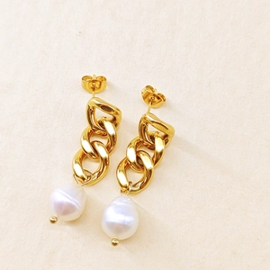 Vue détaillée de boucles d'oreilles chaînes dorées avec perles baroques et fermoirs