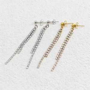 Detail of silver and gold double-row tassel earrings with sparkling cubic zirconia stones