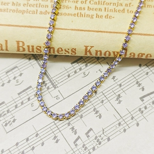 Close-up of gold lavender zircon tennis bracelet on vintage sheet music background