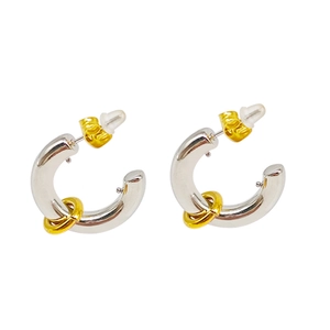 Close-up of two-tone C-shaped hoop earrings with gold-plated ring charms and butterfly backings