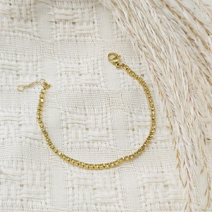 Close-up of gold-plated tennis bracelet featuring yellow square-cut cubic zirconia crystals