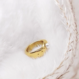Detailed close-up of golden lava style wide ring with pearl accent and geometric cutouts