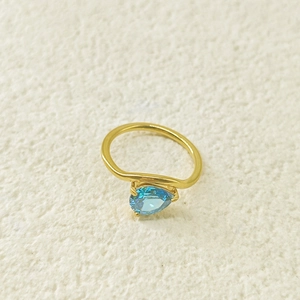 Détail d'une pierre en zircon bleu en forme de poire sur bague en acier doré