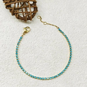 Close-up of a gold adjustable bracelet with sparkling sky blue round-cut crystals