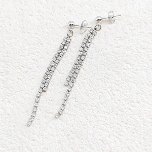 Macro detail of elegant silver long tassel earrings featuring double rows of zircon crystals