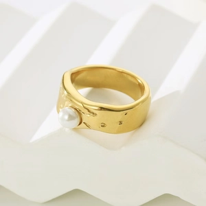 Detail of gold liquid lava ring with irregular hammered texture and white baroque pearl