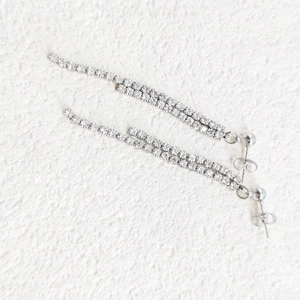 Detailed close-up of elegant silver tassel earrings with double-row cubic zirconia