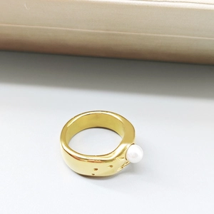 Close-up of golden lava-style ring with wide band and single white baroque pearl inlay