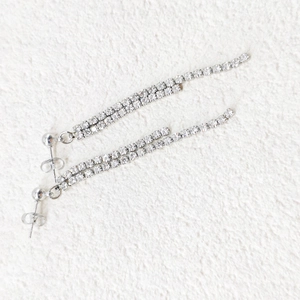Detailed macro of silver long tassel earrings featuring double-row zircon crystals