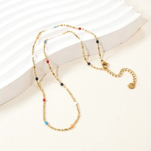 Detail of gold stainless steel necklace with colorful beads and lobster clasp closure