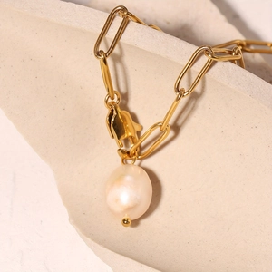 Elegant gold paperclip chain necklace with a large white freshwater pearl pendant detail