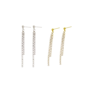 Detail showing long double-row tassel earrings in gold and silver with zircon stones