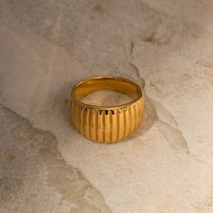 Macro shot of gold-plated croissant textured ring showing detailed vertical ridges